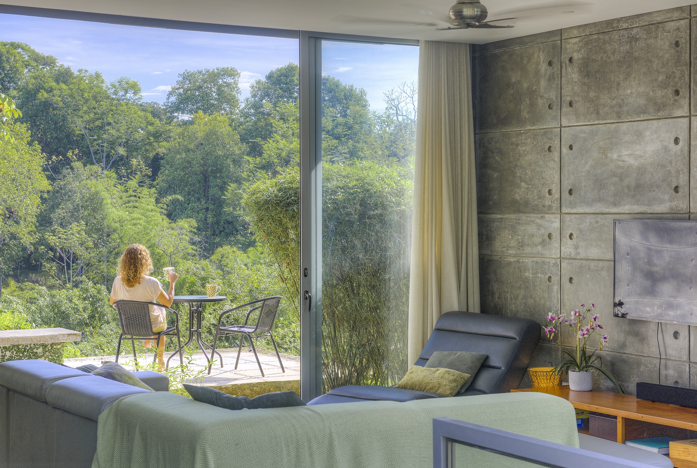 Guest enjoying morning coffee on jungle balcony at Los Laureles Costa Rica